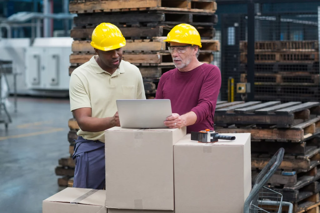 Two warehouse workers using a laptop for BBS training